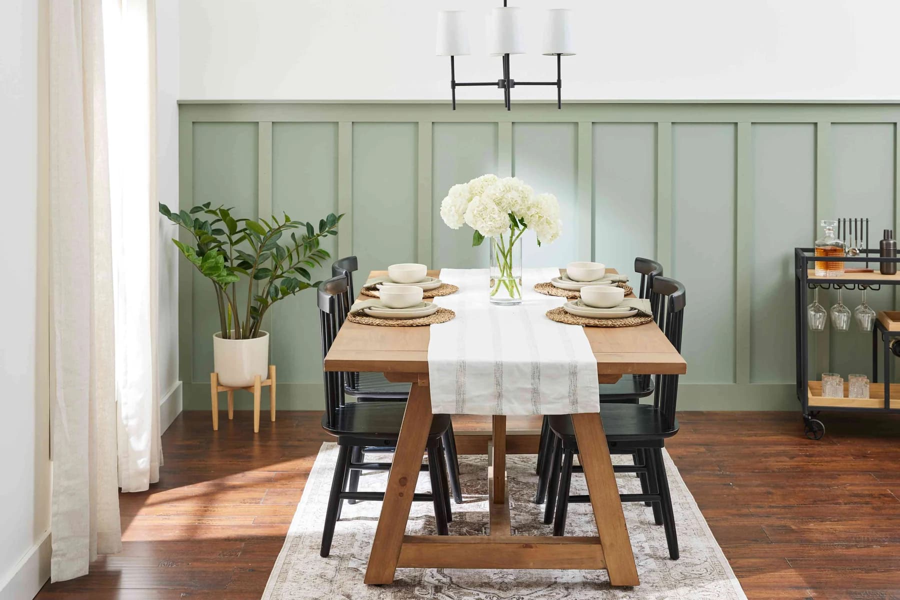 Sage wainscoting in a bright dining room