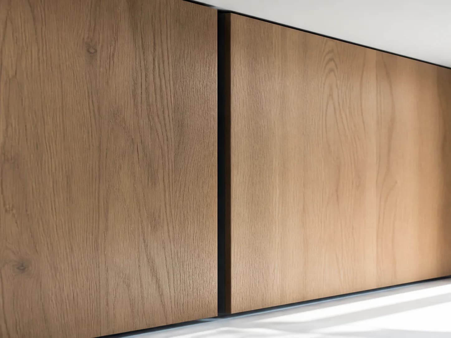 Original close detail of two warm oak-look finished panels meeting at a narrow dark vertical reveal