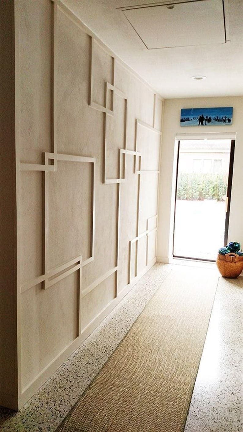 Layered rectangular grid and linework paneling in a bright hallway